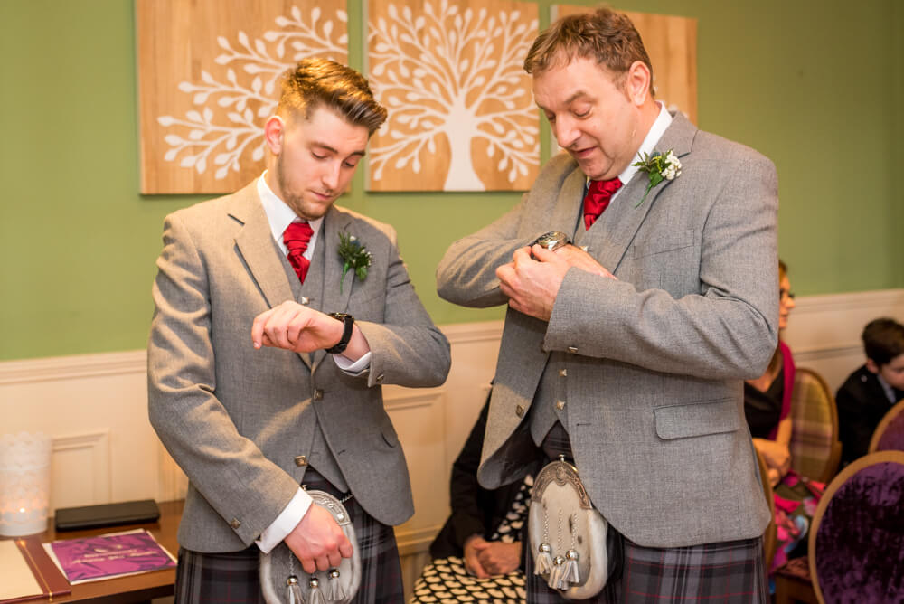 Groom and best man checking their watches