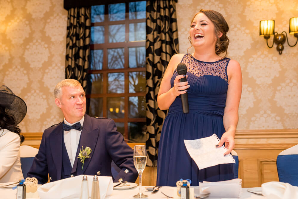 Bridesmaid laughs during wedding speeches