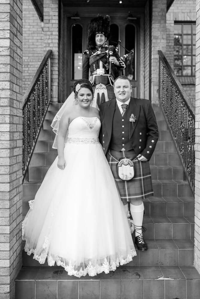 Bride and groom with piper outside the Parkville Hotel