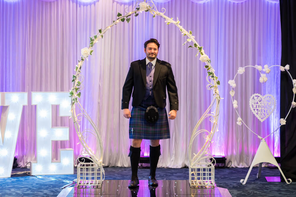Groom in kilt walks down catwalk at wedding show