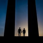 silhouette of couple standing in between columns